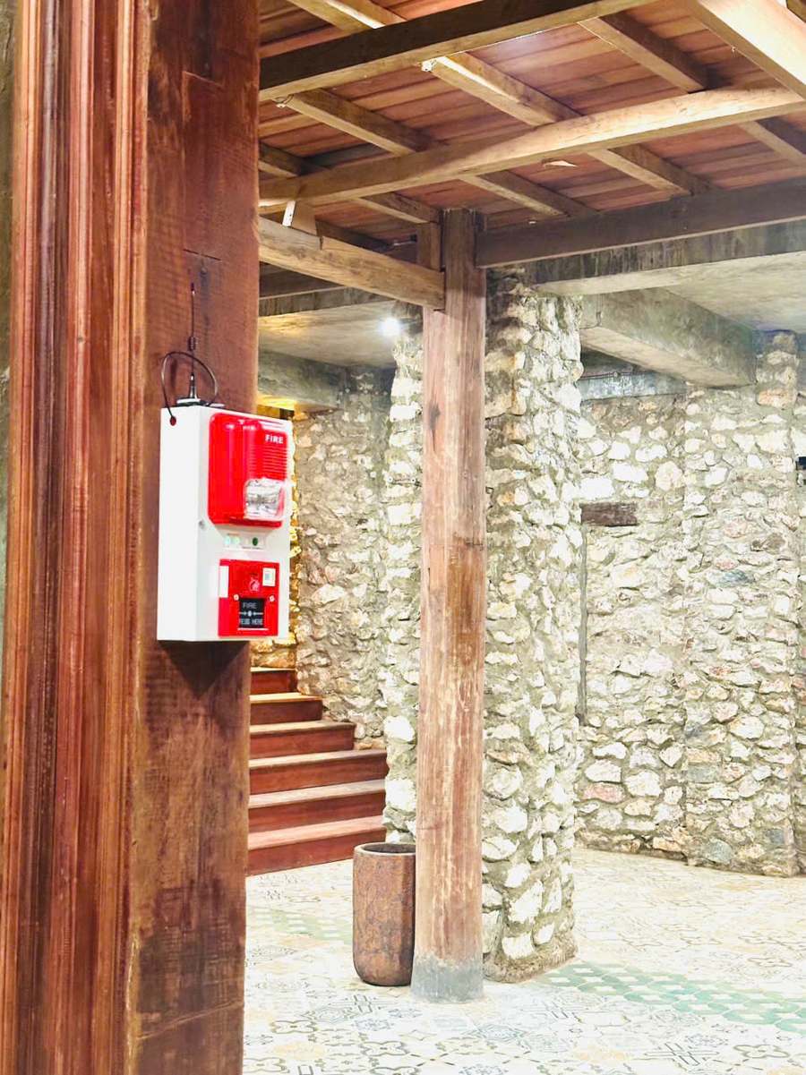 Báo cháy cho resort, khu nghỉ dưỡng: bài toán nhiều khối nhà biệt lập và lời giải không dây 8 Còi đèn báo cháy không dây lắp trên cột gỗ khu vực cầu thang nhà sàn tường đá